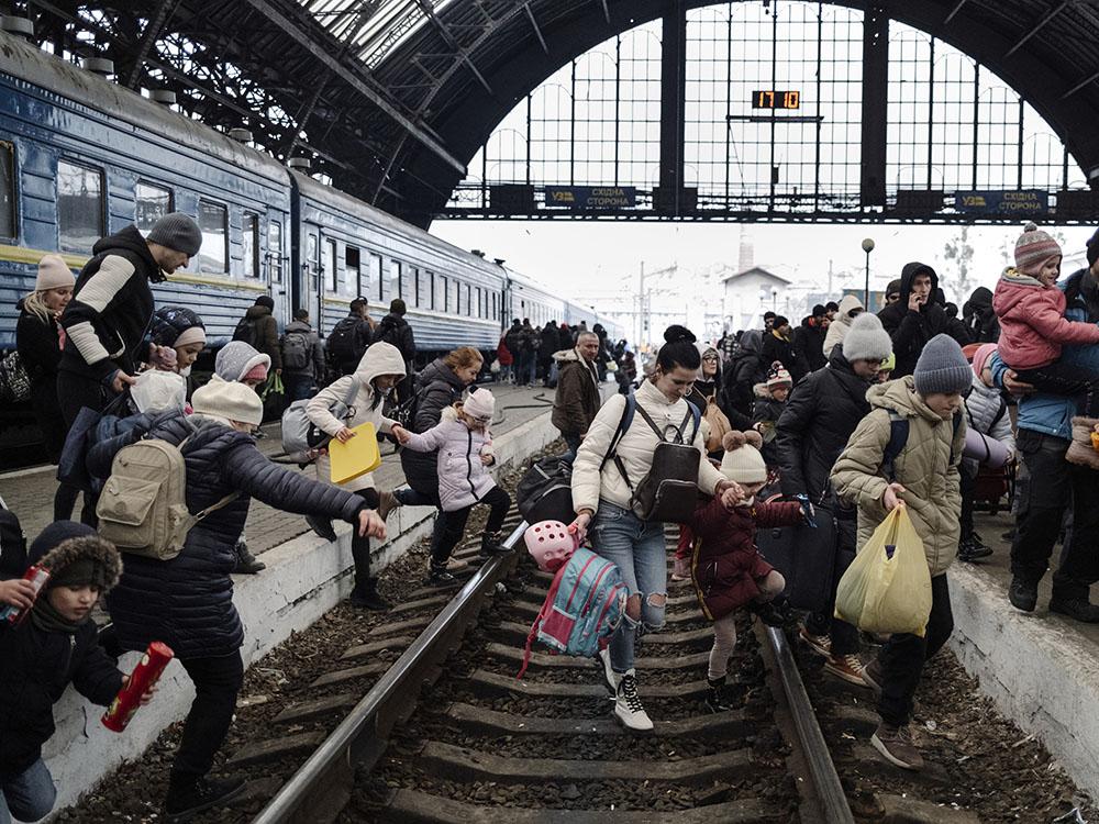 UKRAINE. Lviv. 27 February 2022. Hundreds of people trying to escape the on-going conflict in Ukraine wait for a train to Poland at the central train station in Lviv. 