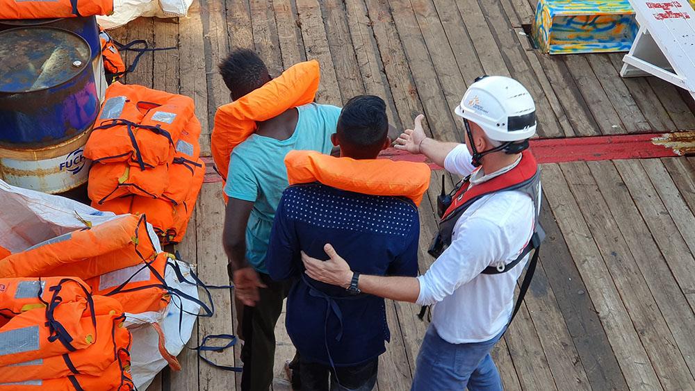 Project Coordinator, Jay Berger, helps rescued people as they come on board Ocean Viking.