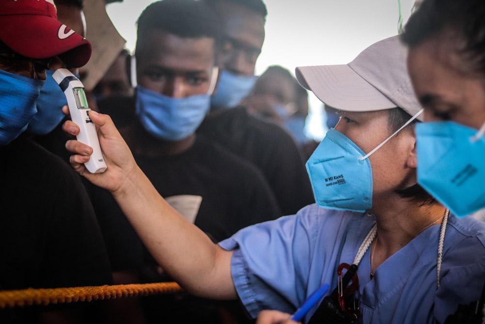 MSF healthworker doing COVID-19 screening on the boat