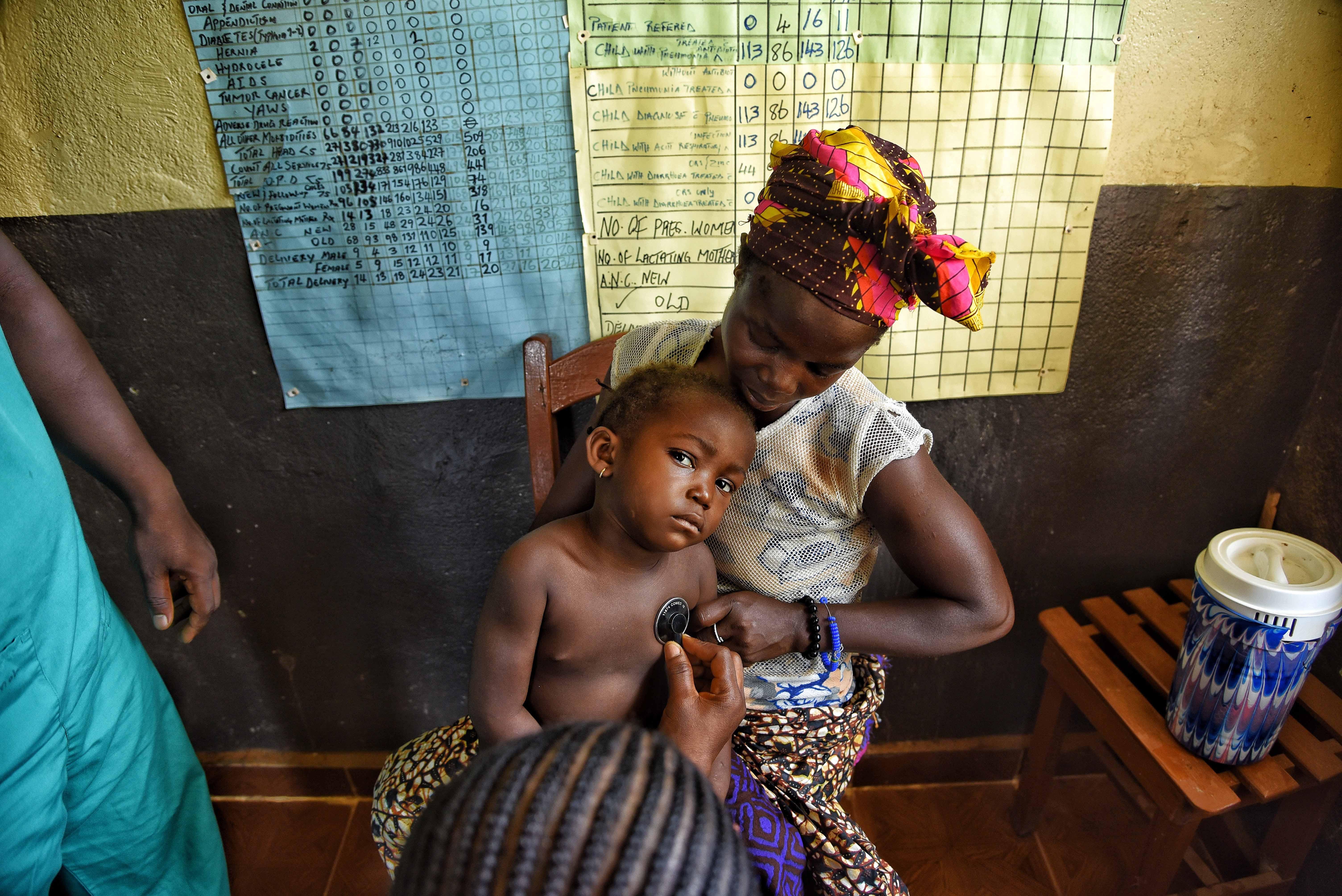 26-year-old Ka Musa holds her child, who has been diagnosed with malaria, during a consultation with Ministry of health staff at the MSF-supported Hangha community health centre in Kenema, Sierra Leone. 