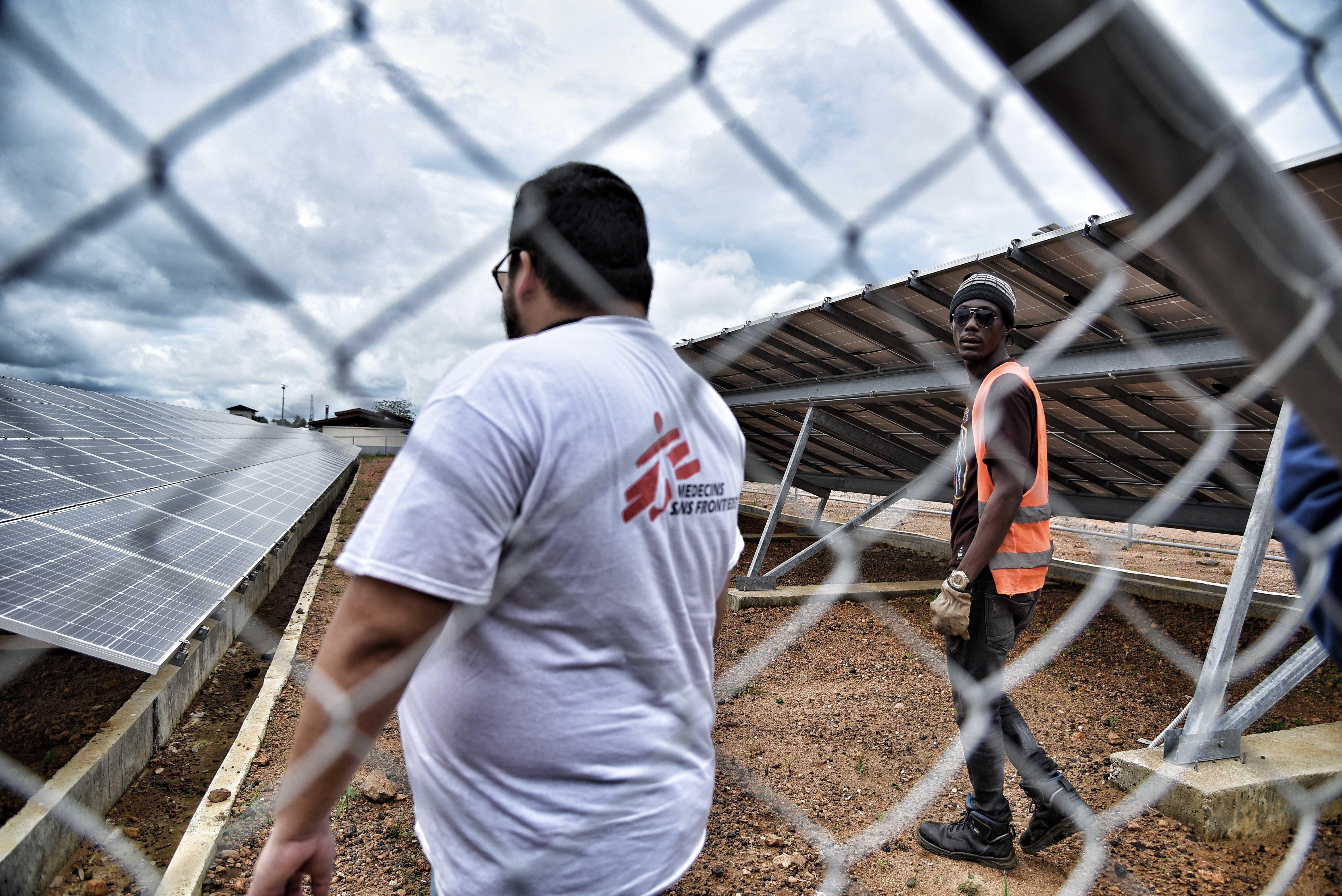 MSF supply manager Gerardo Rivera and logistics supervisor Mohammed Korma checking the solar panels that partially power Hangha hospital in Kenema district. 