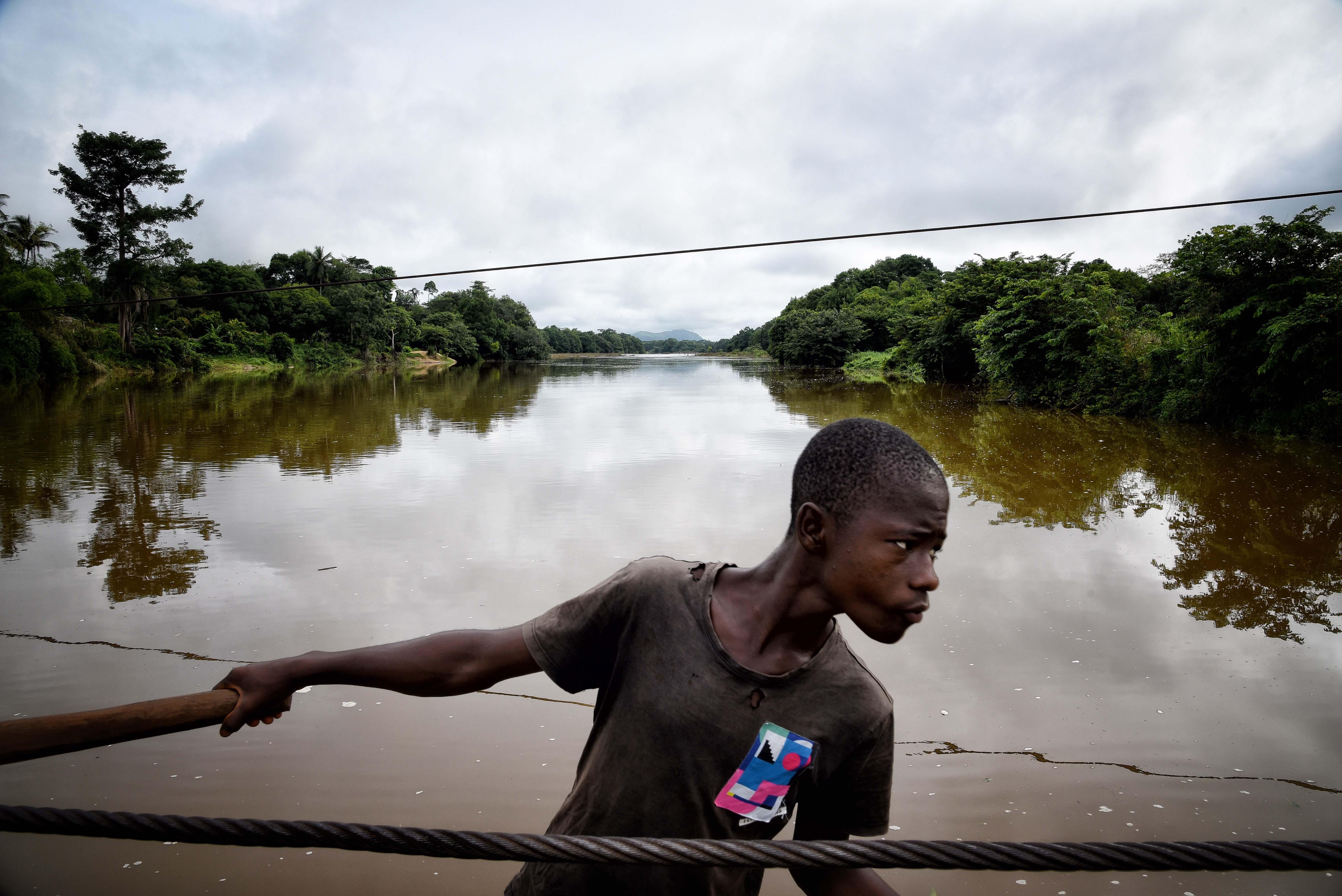 A ferry worker transporting an MSF vehicle across the Sewa river in Kenema district, eastern Sierra Leone. 