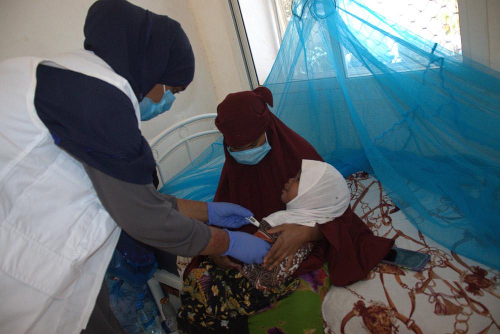 MSF nurse attending to a child with measles