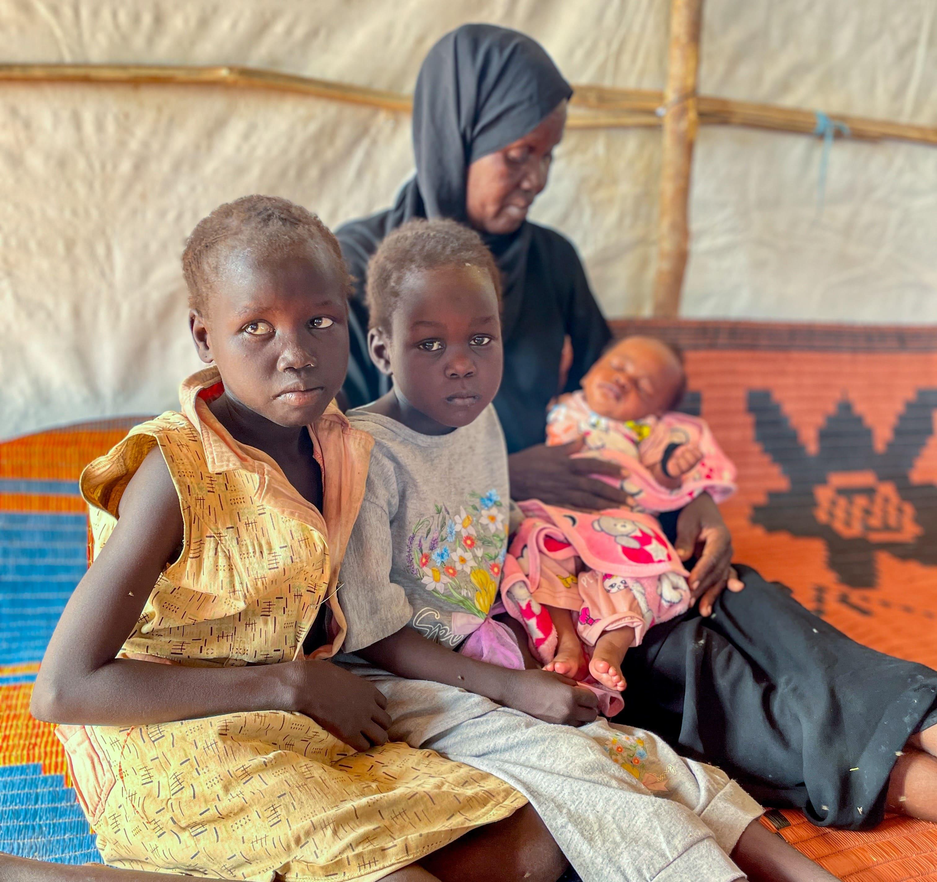 Sudan War & South Sudan Refugees: Achol Akiri, 40 years old, came to MSF mobile clinic in the Transit Centre because her granddaughter was sick.