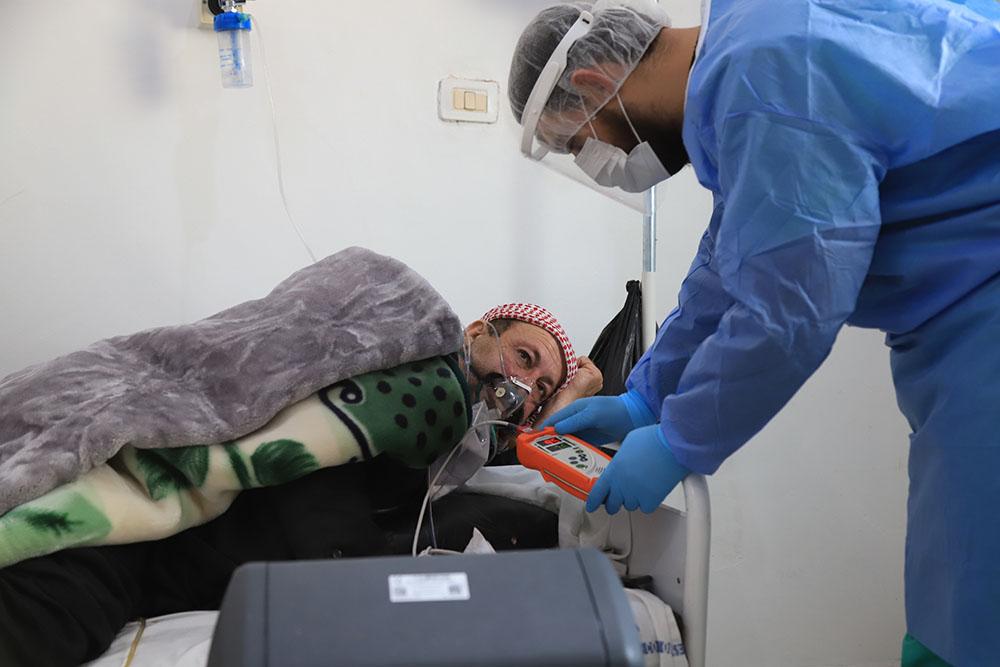 Nurse checking a patient’s oxygen level inside the ward for patients with suspected COVID-19.