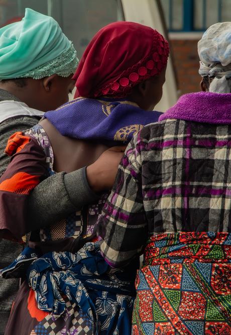 Survivors of sexual and gender-based violence stand with their arms around each other