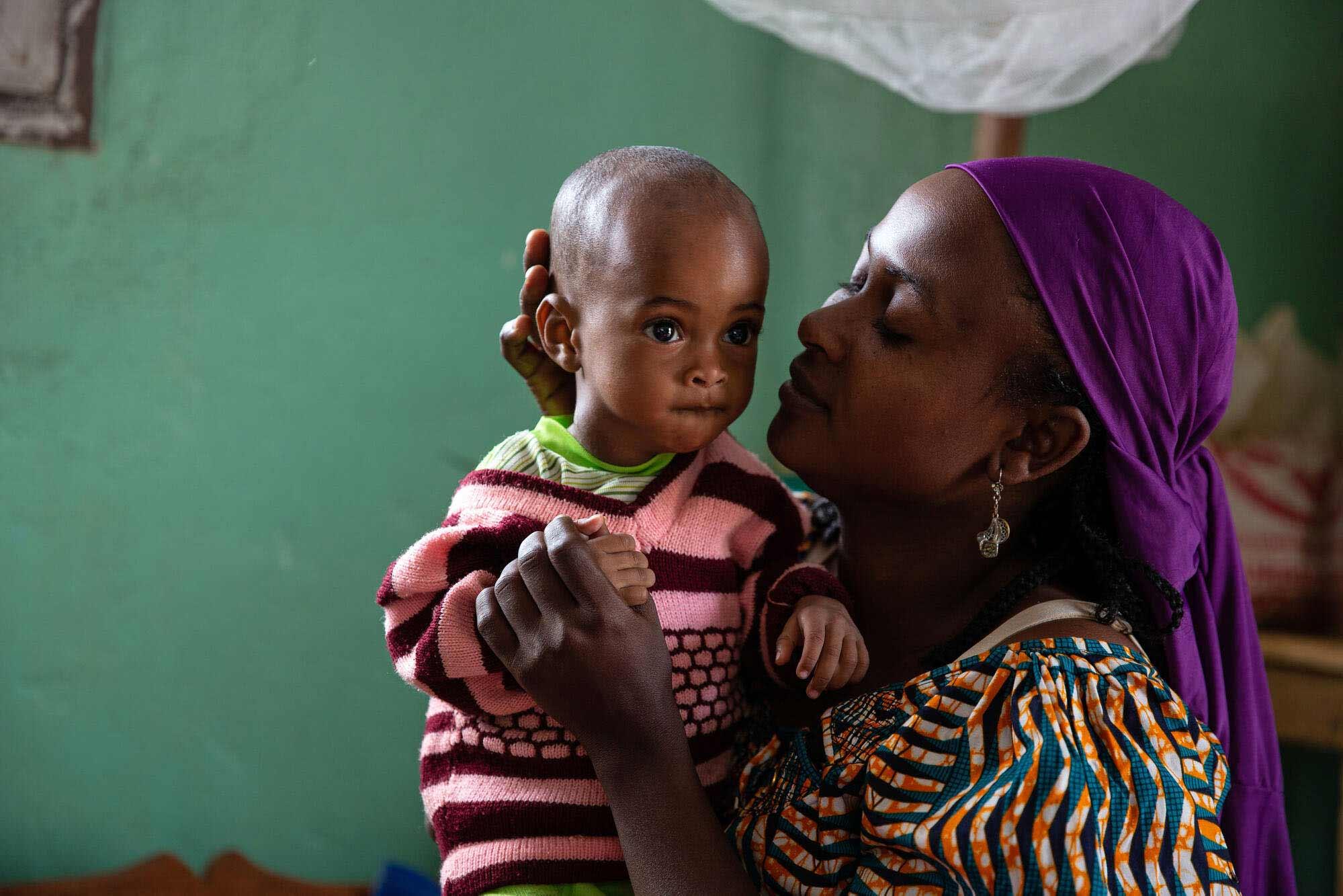 A child with measles , being comforted by her mother. 