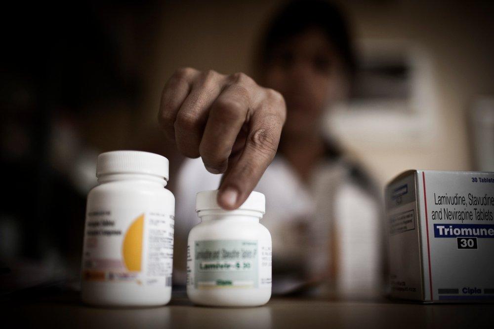 A women checks the labels on bottles of medication. Access to medi