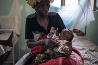 Rachel, a 35-year-old displaced woman, holds her 6-month-old son, Merci Dode, in the intensive therapeutic feeding unit at the MSF-supported Rutshuru hospital on July 16, 2022, in North Kivu province, eastern Democratic Republic of Congo. Merci Dode has been treated for a week for severe acute malnutrition. Rachel and her 8 children were forced to flee their village in March due to clashes between the Congolese army and the M23 armed group.