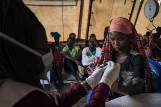 Rachel, a 20-year-old displaced woman, waits her turn for a medical consultation in the MSF mobile clinic at Rugabo Stadium, which has been transformed into a site for conflict-displaced people, in Rutshuru Center, in North Kivu province, eastern Democratic Republic of Congo. She is suffering from high fever, chills and headaches. She tested positive for malaria.