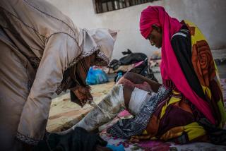 A woman with burns detained in Sorman at female-only detention centre around 60km west of Tripoli, Libya. She is assisted by another detainee.