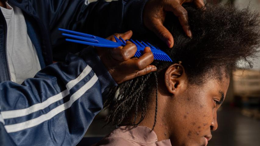 A female survivor braids another woman’s hair