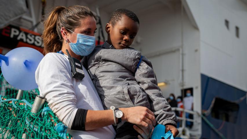 MSF Team member carries one of the rescued children