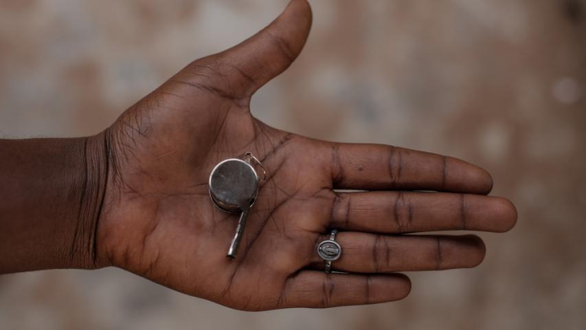 Am open palm with a whistle in it. This is given out in Nigeria to protect from sexual violence, and the devastating effects that follow social violence and exclusion