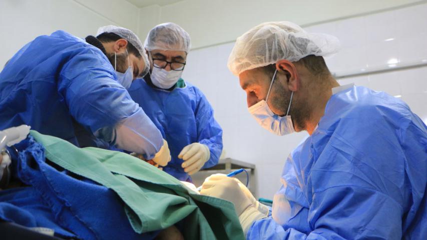 Syrian doctors operate on a patient in a hospital in Atmeh