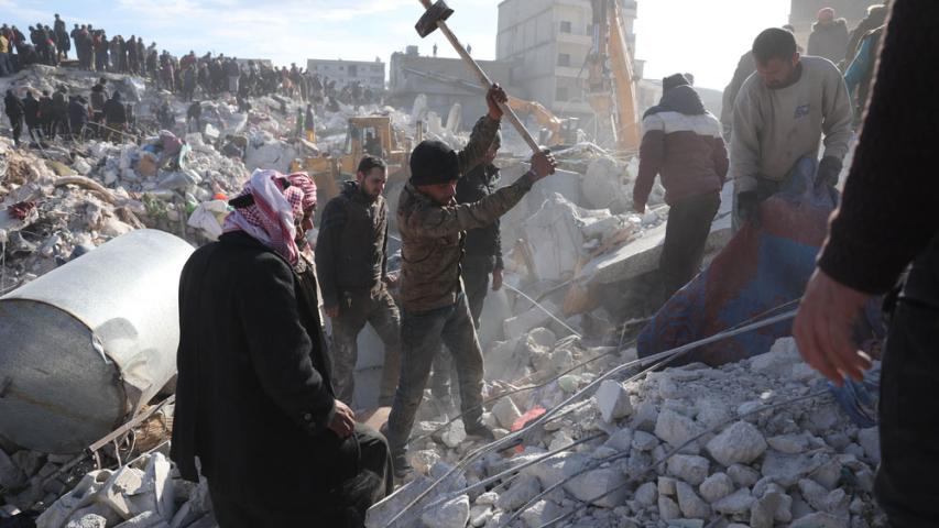 People dig through the rubble of collapsed buildings